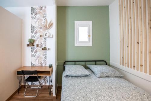 une petite chambre avec un lit et un bureau dans l'établissement Zola - Joli studio tout confort Villeurbanne, à Villeurbanne