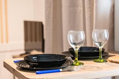 une table avec deux verres et une assiette et une assiette dans l'établissement Zola - Joli studio tout confort Villeurbanne, à Villeurbanne