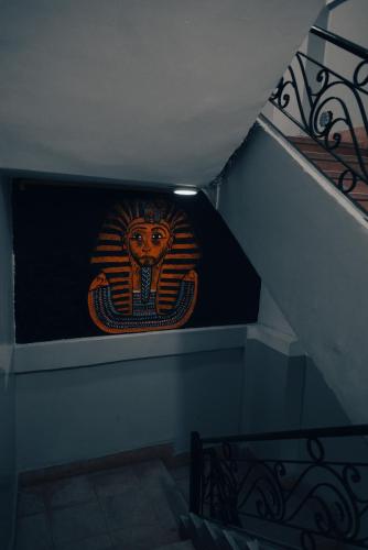 a staircase with a painting of a face on the wall at Explore Stars Pyramids View in Cairo