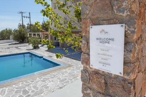 - un panneau indiquant que vous serez accueilli à côté d'une piscine dans l'établissement GIN Wellness Hotel, à Pyrgos