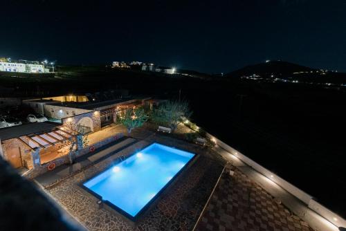 a large swimming pool on top of a building at night at GIN Wellness Hotel in Pyrgos
