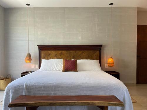 a bedroom with a large bed with a wooden headboard at *CASA ALUXES- Guesthouse* in Cancún