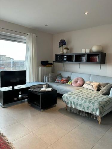 uma sala de estar com um sofá e uma televisão em Walter Vilain 0503 - 5 min De La Plage em Koksijde