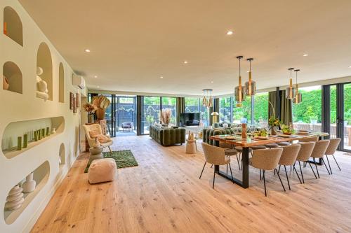 a dining room and living room with a table and chairs at Extraordinaire Villa 5 étoiles 12 personnes 7 min Lille in Marcq-en-Baroeul