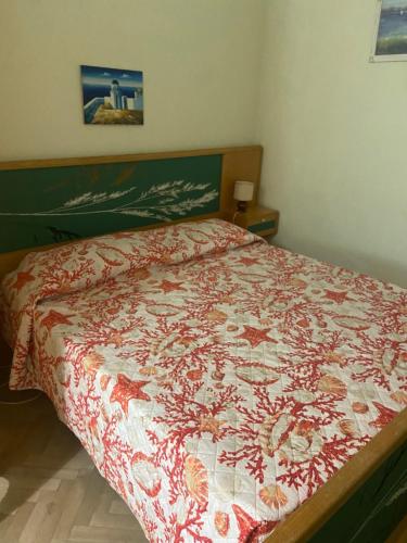 - une chambre avec un lit et une couette rouge et blanche dans l'établissement Appartamento Bouganville, à Levanto