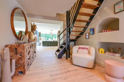 a living room with a staircase and a chair at Extraordinaire Villa 5 étoiles 12 personnes 7 min Lille in Marcq-en-Baroeul