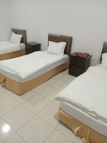 dos camas sentadas una al lado de la otra en una habitación en شقق المجد للشقق المخدومة, en Al Khobar