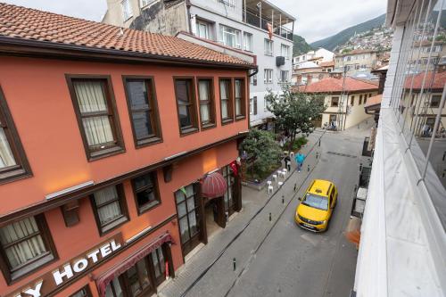 un coche amarillo estacionado en una calle al lado de un edificio en BURSA GRAND FAMİLY HOTEL & SpA, en Bursa