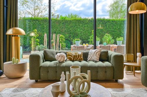 a living room with a green couch and a large window at Extraordinaire Villa 5 étoiles 12 personnes 7 min Lille in Marcq-en-Baroeul