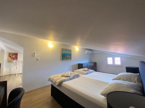 a bedroom with a large bed with white sheets at Apartmani Spaija in Kaštela