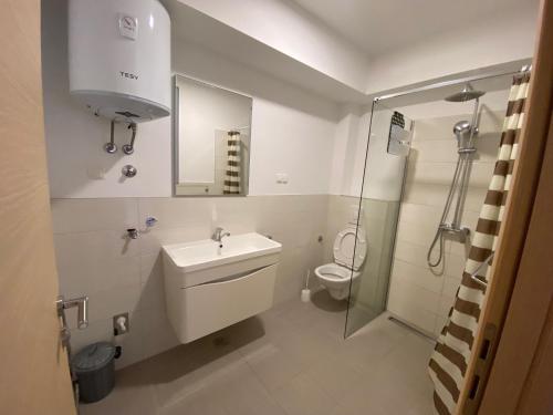 a bathroom with a toilet and a sink and a shower at Apartmani Spaija in Kaštela