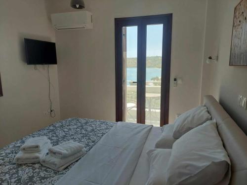 een witte slaapkamer met een bed met handdoeken erop bij Κamares View (Αύρα) in Ayeranós