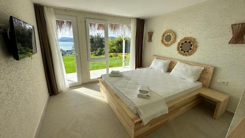 a bedroom with a large bed and a large window at The Roof Ada in Adalar