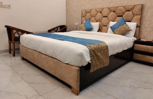 a bedroom with a large bed with a large headboard at MK Regency in Greater Noida