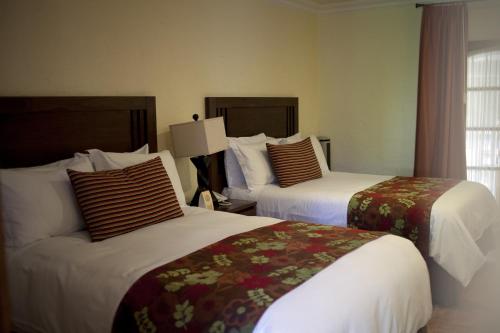 a hotel room with two beds and a window at Hotel Boutique La Granja in Tequisquiapan