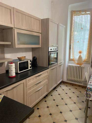 una cucina con armadi in legno e forno a microonde di Appartamento Bouganville: CITRA: 011017-LT-0910 a Levanto
