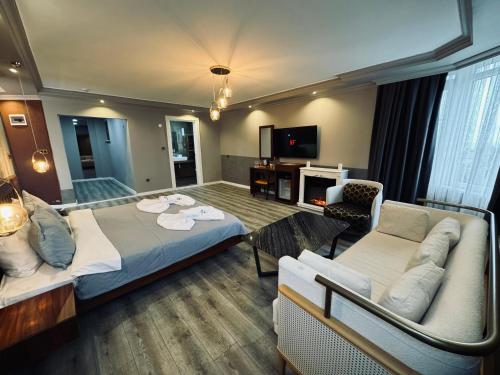 een kamer met een bed, een bank en een tv bij Treekos Suite Hotel in Arnavutköy