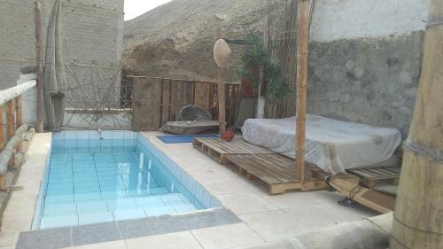 1 dormitorio con cama y piscina en Huanchaco Surf Camp, en Huanchaco