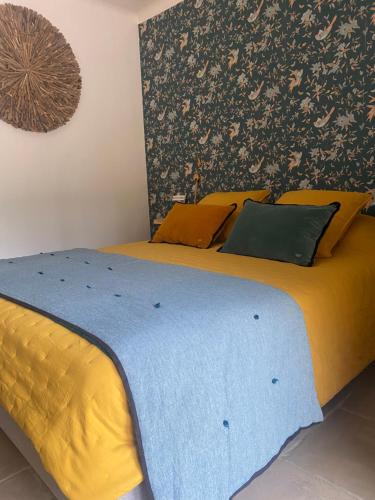 um quarto com 2 camas com lençóis amarelos e azuis em Maison Terre de Lune em Mondragon