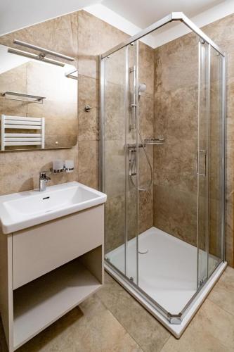 a bathroom with a shower and a sink at Relax Hotel Stork in Lednice