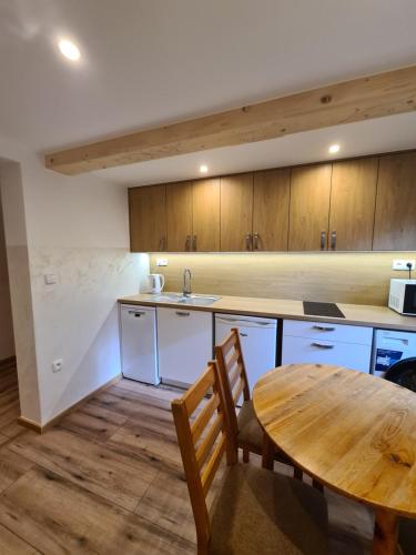 a kitchen with a wooden table and a wooden table and a table and chairs at Apartamenty U Samków in Zakopane