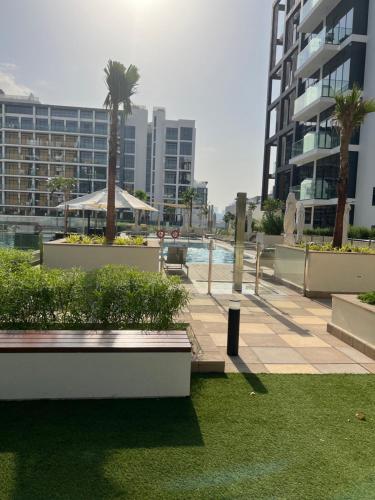 a resort with a pool and palm trees and buildings at Luxury Studio Brand New with HighEnd Furnishings in Dubai