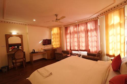 een slaapkamer met een bed en een woonkamer bij roy castle in Dharamshala