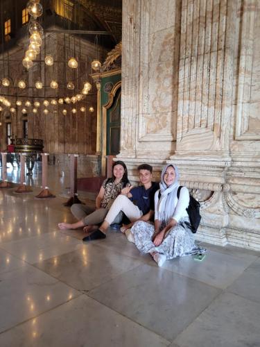 three women sitting on the floor of a building at Explore Stars Pyramids View in Cairo