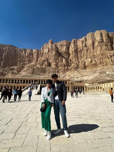 a man and woman standing in front of a mountain at Explore Stars Pyramids View in Cairo