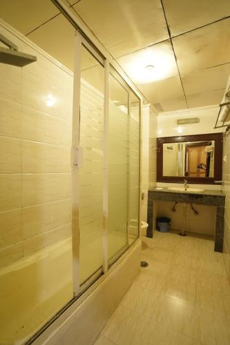 a bathroom with a glass shower and a sink at roy castle in Dharamshala