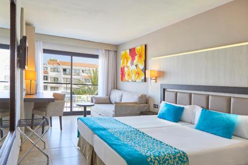 a hotel room with a bed and a living room at FERGUS Style Bahamas in Playa d'en Bossa