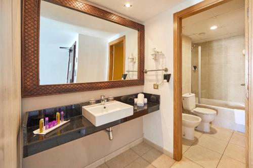 a bathroom with a sink and a toilet and a mirror at FERGUS Style Bahamas in Playa d'en Bossa