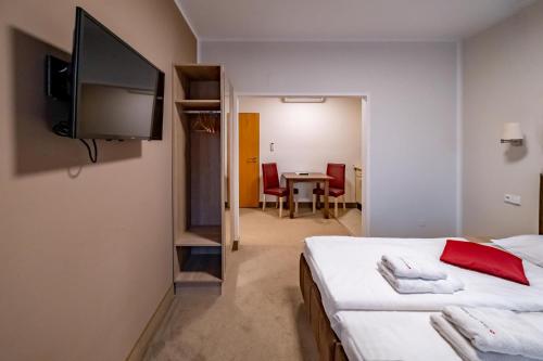a bedroom with a bed and a flat screen tv at Relax Hotel Stork in Lednice