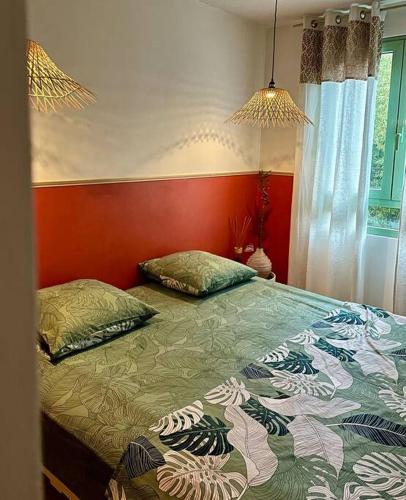 a bedroom with a bed with a red wall at Appartement in Fort-de-France