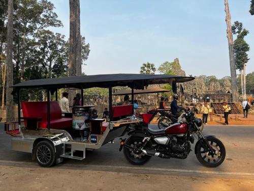 a horse drawn carriage with a motorcycle parked next to it at Lotus Haven Villa in Siem Reap