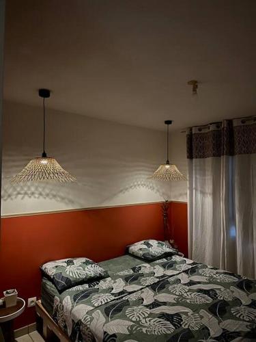 a bedroom with a bed with two lights above it at Appartement in Fort-de-France
