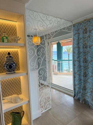 Cette chambre dispose d'une porte offrant une vue sur l'océan. dans l'établissement Annabel's Suite Apartament, à Roquebrune-Cap-Martin