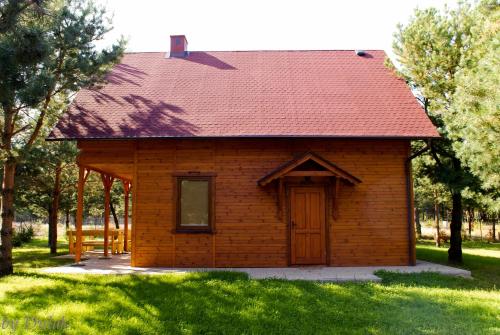 mały ceglany dom z czerwonym dachem w obiekcie Kociewiak Wycinki w mieście Wycinki