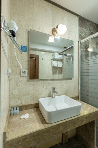 a bathroom with a sink and a mirror at Bursa Grand Family HOTEL in Bursa