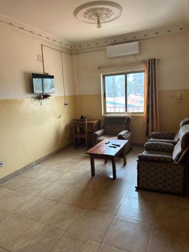 uma sala de estar com um sofá e uma mesa em Gust Hotel em Bangui