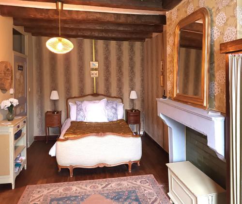 a bedroom with a bed and a fireplace at Au bord de la rivière in Verteuil-sur-Charente