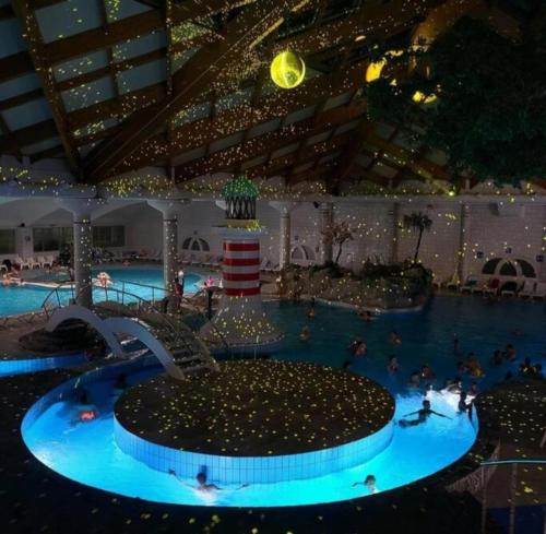 a pool with people swimming in it at night at Green Sky House in Mostec