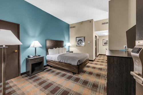Un pat sau paturi într-o cameră la Quality Inn Roseville-Detroit North