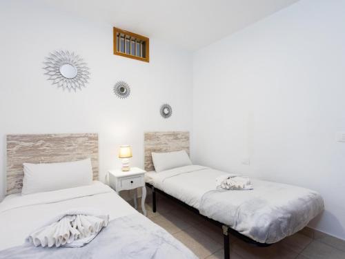 2 camas en una habitación con paredes blancas en EK Brisa Del Mar Caleta Arico, en Arico