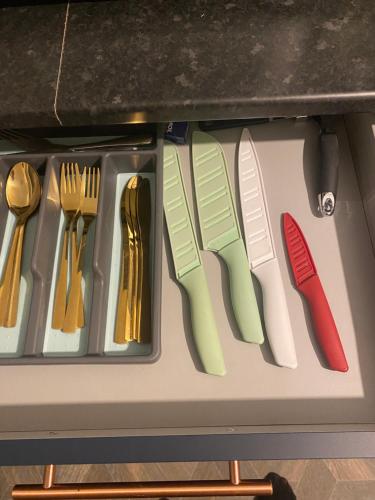 a drawer filled with different colored knives and utensils at Mountain View in Llwyn-y-pia