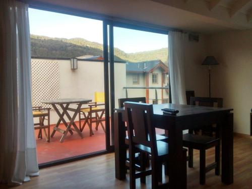 ein Esszimmer mit einem Tisch und Stühlen sowie einem Balkon in der Unterkunft Monoambiente céntrico equipado - AlquilaMiCasa in San Martín de los Andes