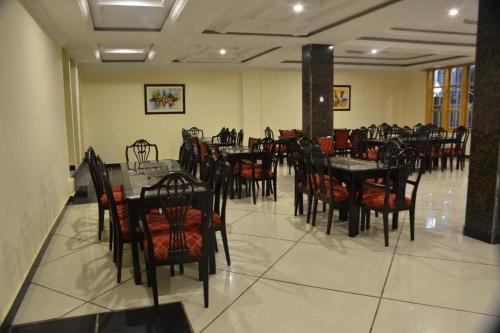 uma sala de jantar com mesas e cadeiras num restaurante em Magnum Hotel em Battakundi