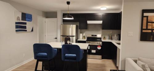 a kitchen with a white counter and blue chairs at Kings Place in Ottawa