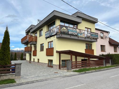 un bâtiment jaune avec un panneau sur lequel figure un panneau dans l'établissement Hotel Demanova Apartments Dependance, à Liptovský Mikuláš