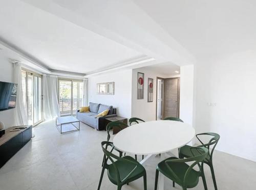 un salon avec une table, des chaises et un canapé dans l'établissement Modern 2 Bedroom in the Heart of Cannes, à Cannes